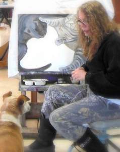 photo of the artist Elizabeth Lisa Petrulis in studio w unfinished Cat Fight and Sadie looks on.