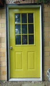 light yelowing green door with black trim, studio door