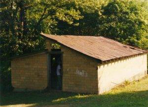 The chicken house exterior as we found it. With graffiti, rusted roof, and no door.