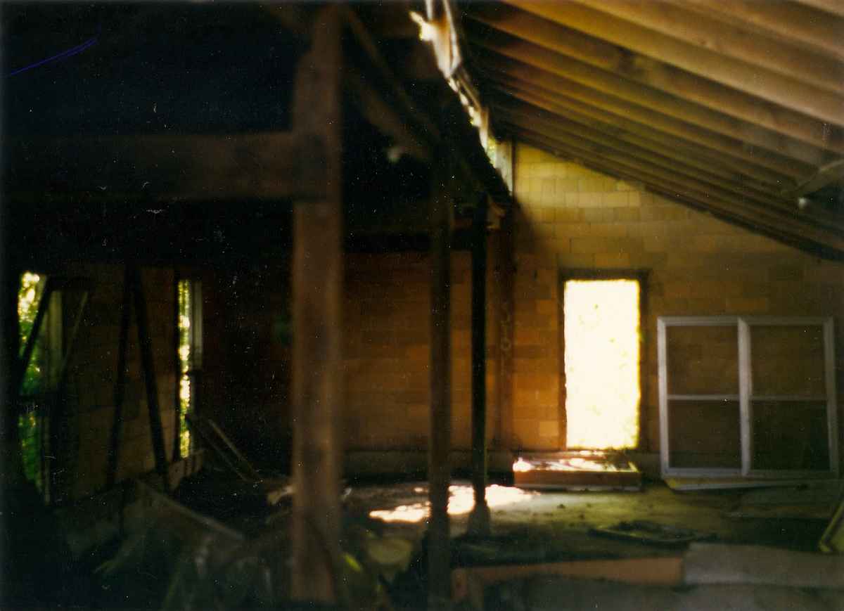 Chicken house masonry building interior as found without doors or windows and strewn with debris and trash.