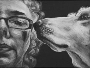 Intimate close up portrait in Black and white. Shows half womans face with glasses looking forward with dog in profile snout touching glasses.