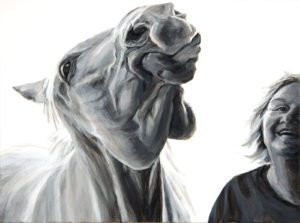 woman and horse with smiling facial expressions seen from neck up